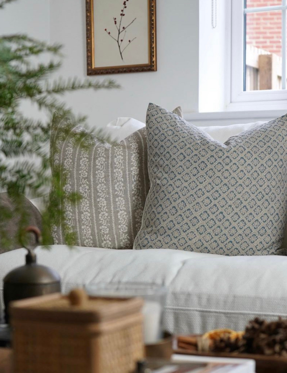Styled image showing a floral cushion on a white csofa