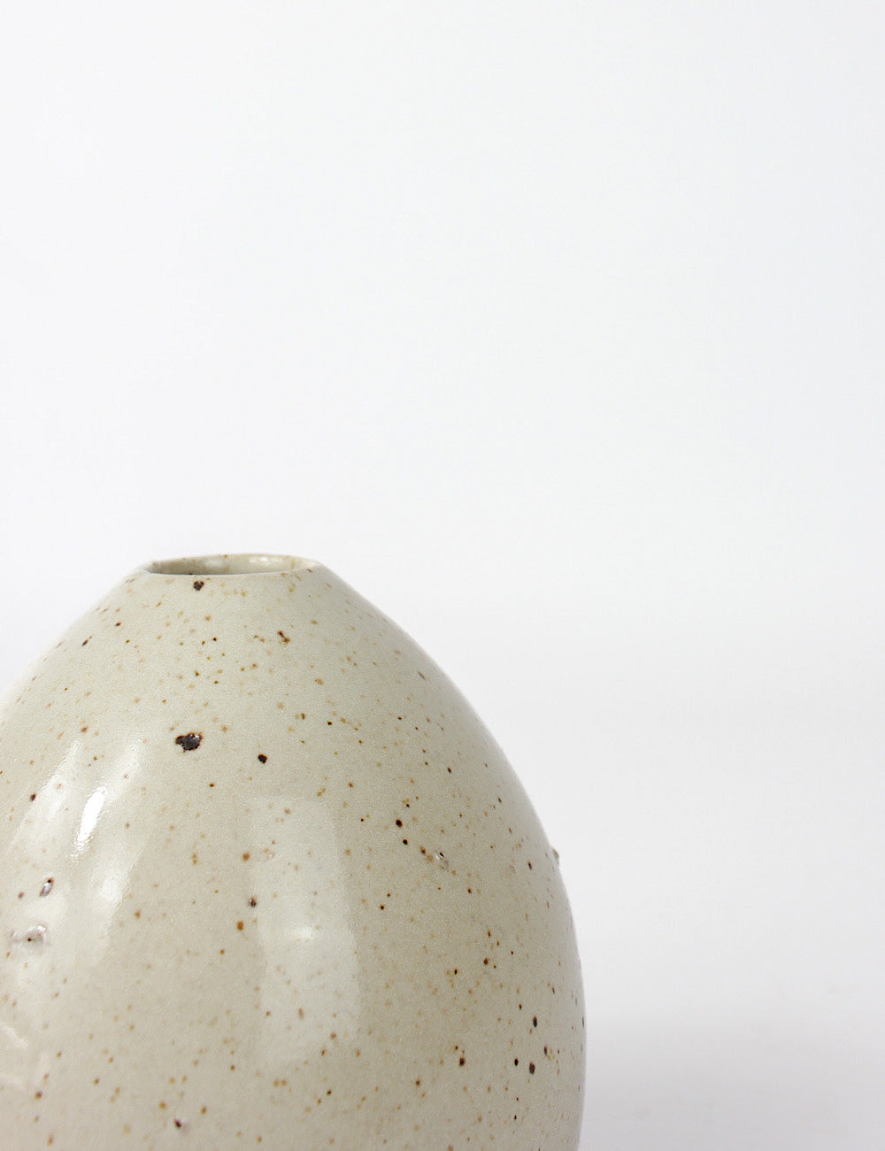 Close up of the Juno small ceramic vase with a speckled off white glaze and porous finish in some areas.