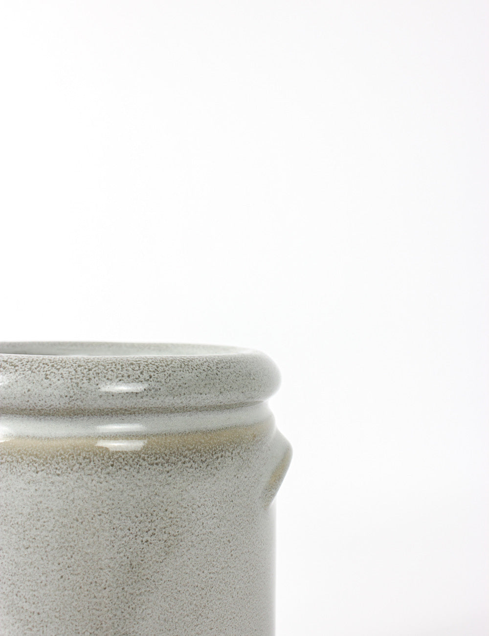 Close up shot of a blue / grey plant pot with a speckled glaze finish and cylindrical body.