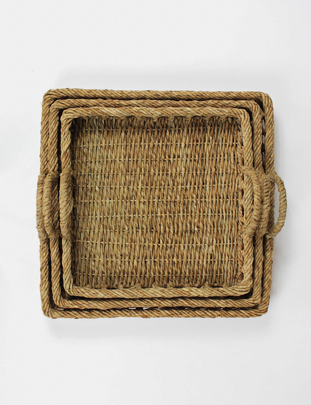 Top shot of three square rattan trays nestled within each other.