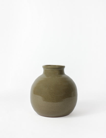 Dark green ceramic vase with round body and narrow bottleneck top opening.