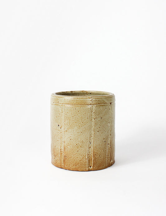 Rustic plant pot with a textured finish and cylindrical body.