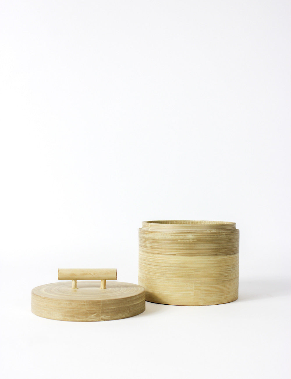 Bamboo canister, a small storage box with a cylindrical shape and fitted lid, with a t-bar handle. Picture shows the lid off. 