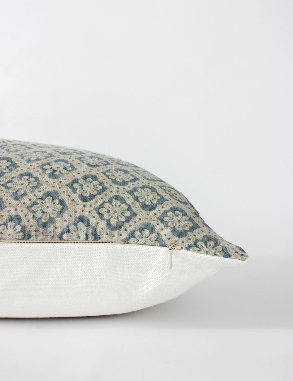 Side view of the Lana blue cushion cover with a white back and hidden zip. Block print floral design on the front. 