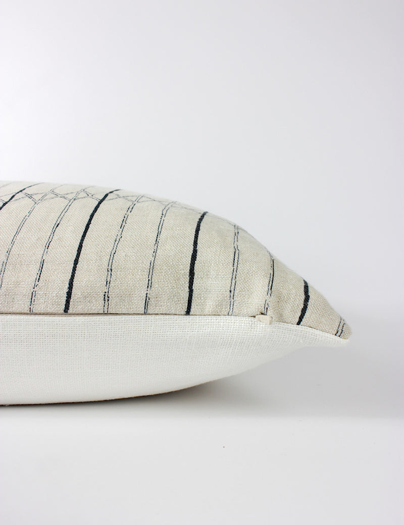 Side view of the Serena scatter cushion capturing its two-tone indigo striped pattern on the front and a plain off-white back and a hidden zip.